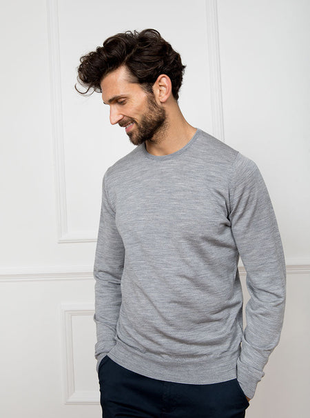 Man wearing silver grey long sleeved crewneck sweater knit in 100% luxury and premium merino wool.